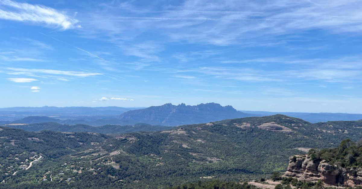 Muntanyes a l'horitzó sota un cel blau.
